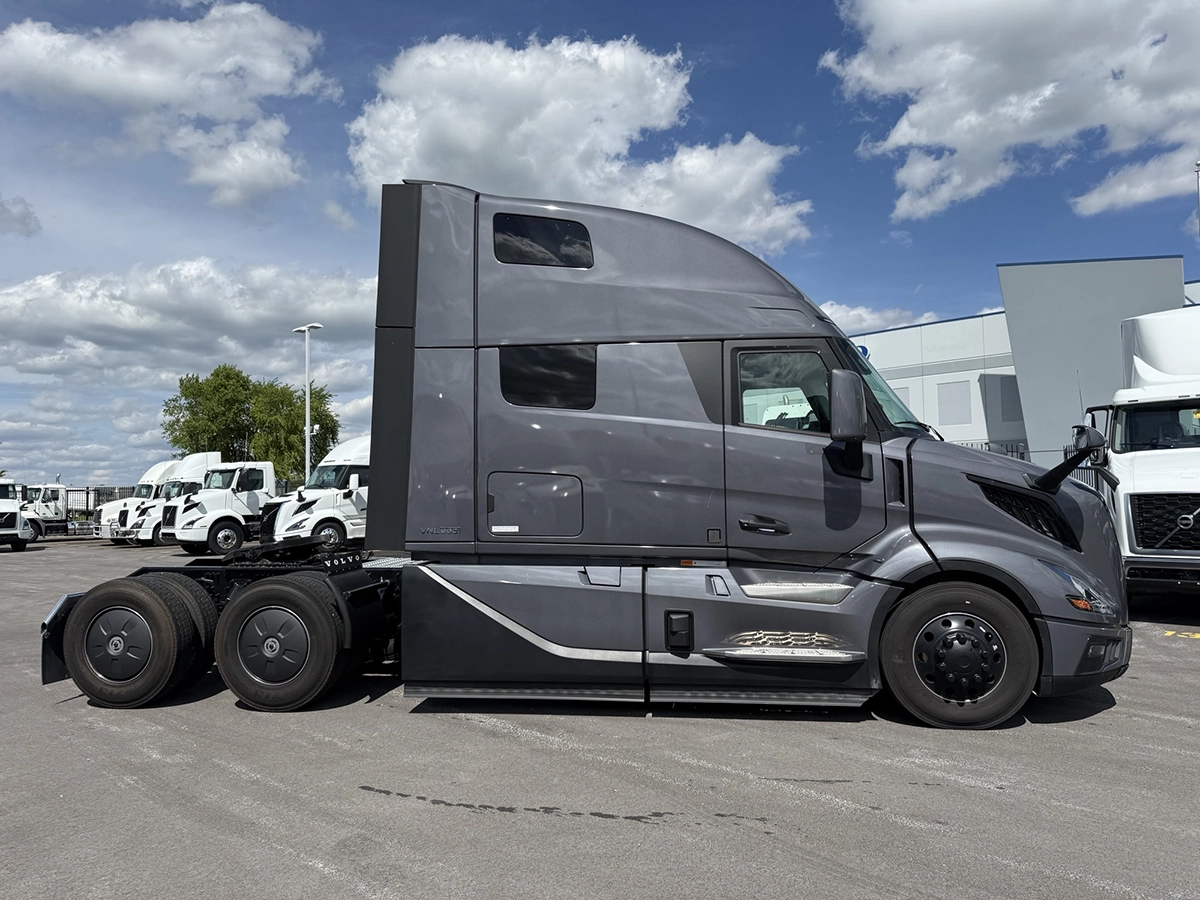 Passenger side view of a gray 2025 Volvo VNL64T860 showing the full profile of the high-roof sleeper cab with upper and lower bunk windows.