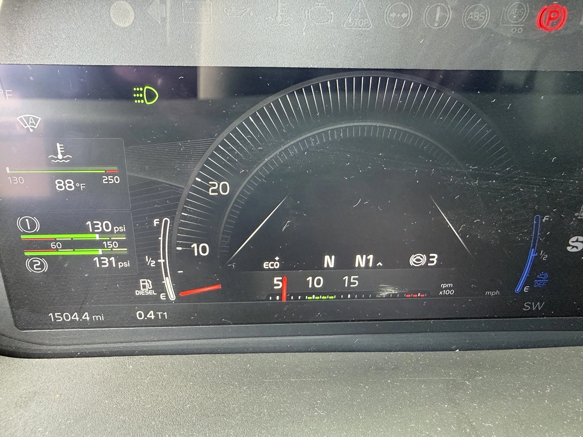 Digital instrument cluster of a 2025 Volvo VNL64T860 showing an odometer reading of 1,504 miles, air pressure gauges, and fuel level.