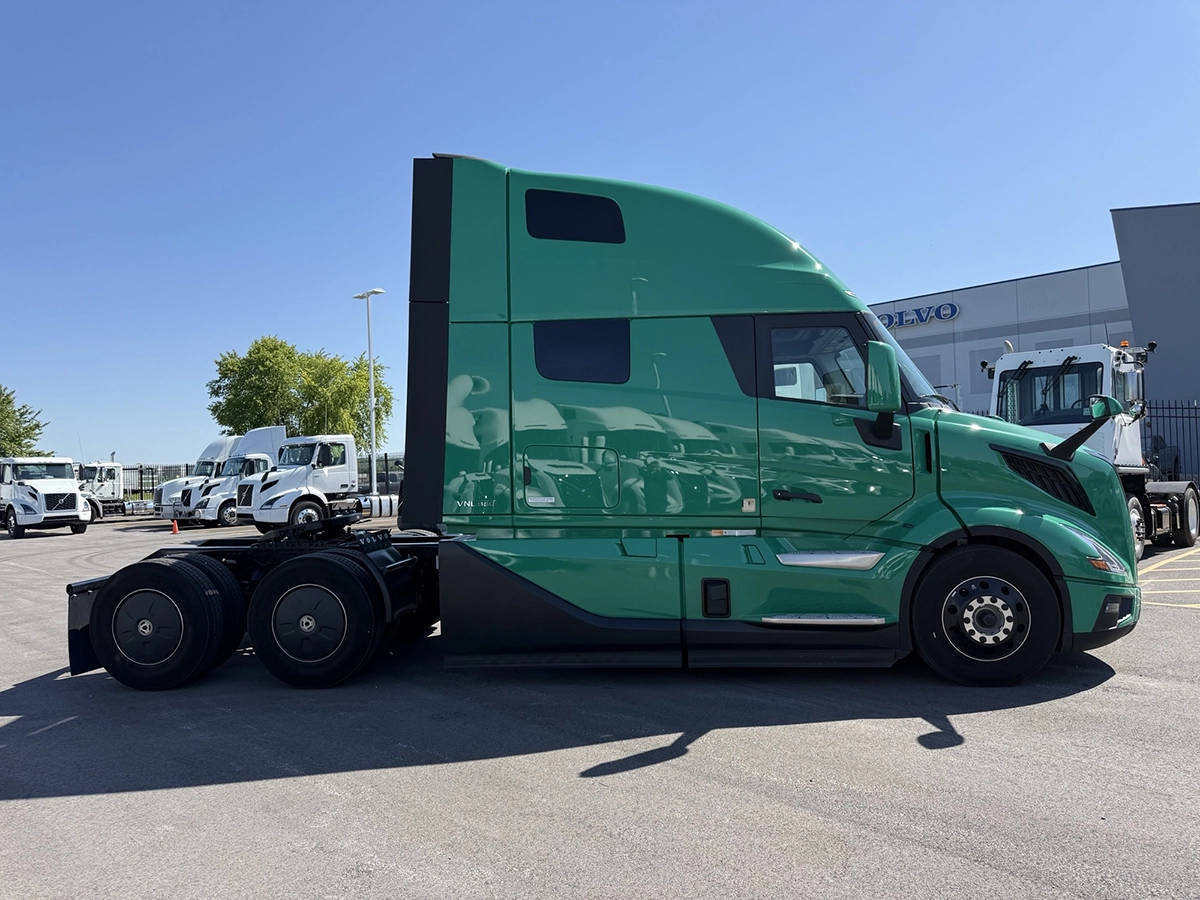 Passenger side view of a green 2025 Volvo VNL64T860 showing the full profile of the high-roof sleeper cab with upper and lower bunk windows.