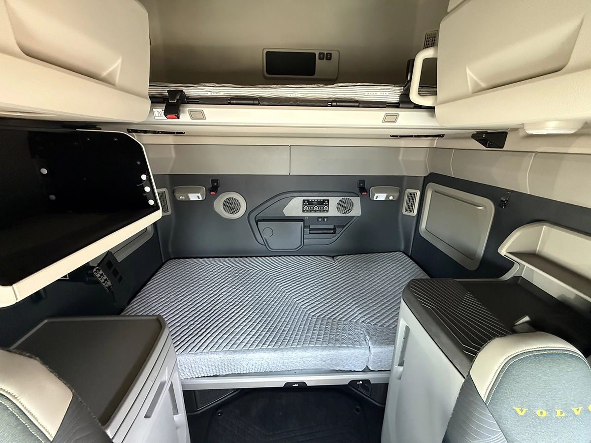 Sleeper berth of a 2025 Volvo VNL64T860 with upper and lower bunks, a lower bunk mattress, overhead storage cabinets, and climate controls.