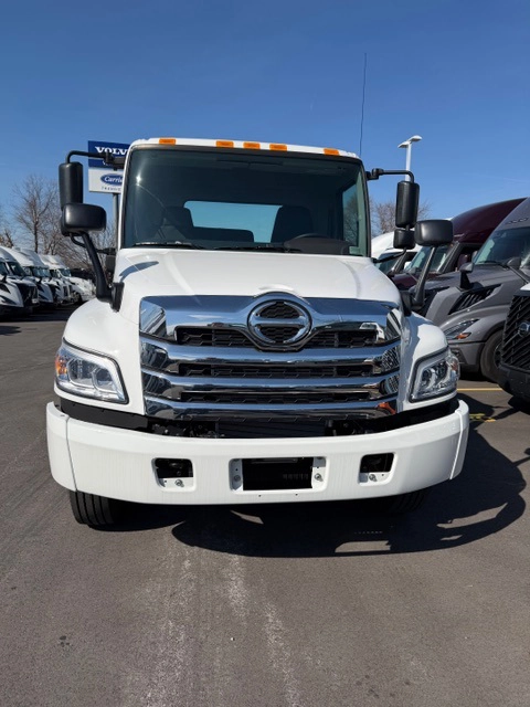 Front view of a white 2026 Hino L6 truck with a chrome grille, Hino badge, and dual side mirrors.