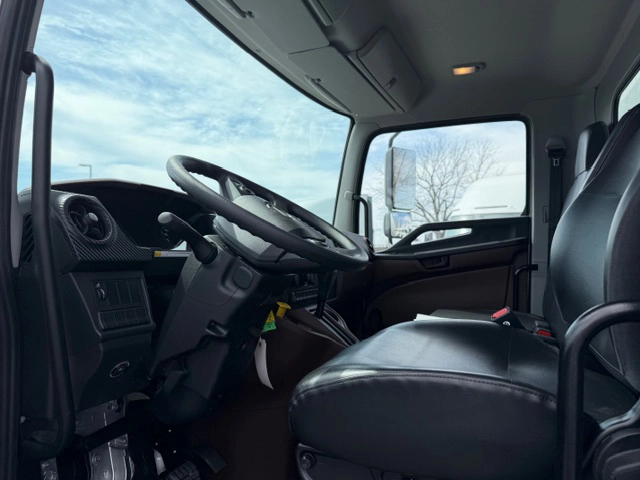 Interior cab view of a 2026 Hino L6 showing the steering wheel, dashboard controls, and black seating.