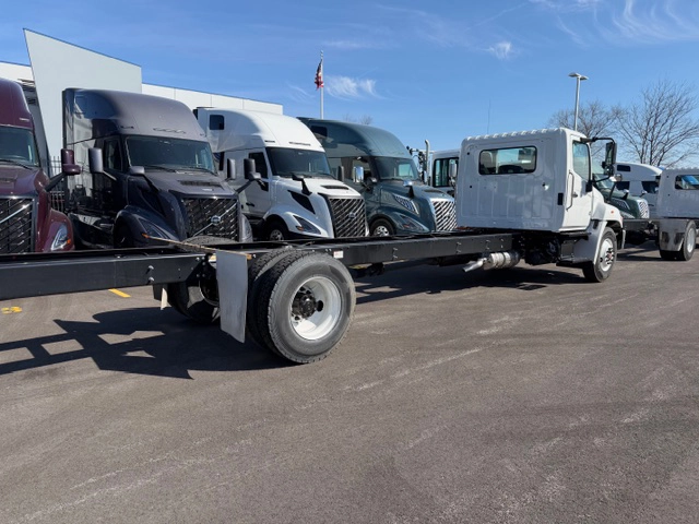 Rear passenger side view of a white 2026 Hino L6 cab and chassis truck showing the full length of the exposed frame rails and single rear axle.