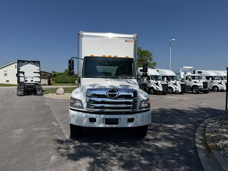 Front view of a white 2026 Hino L6 box truck with a chrome grille, Hino badge, and dual side mirrors.