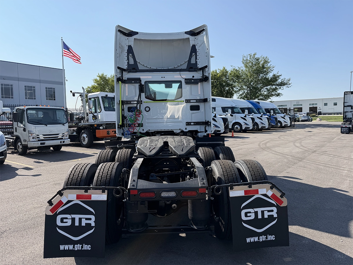 Straight rear view of a white Volvo day cab truck tractor with the cab tilted forward, showing tandem axles, air suspension, and GTR-branded mud flaps, parked at Gateway Truck & Refrigeration.